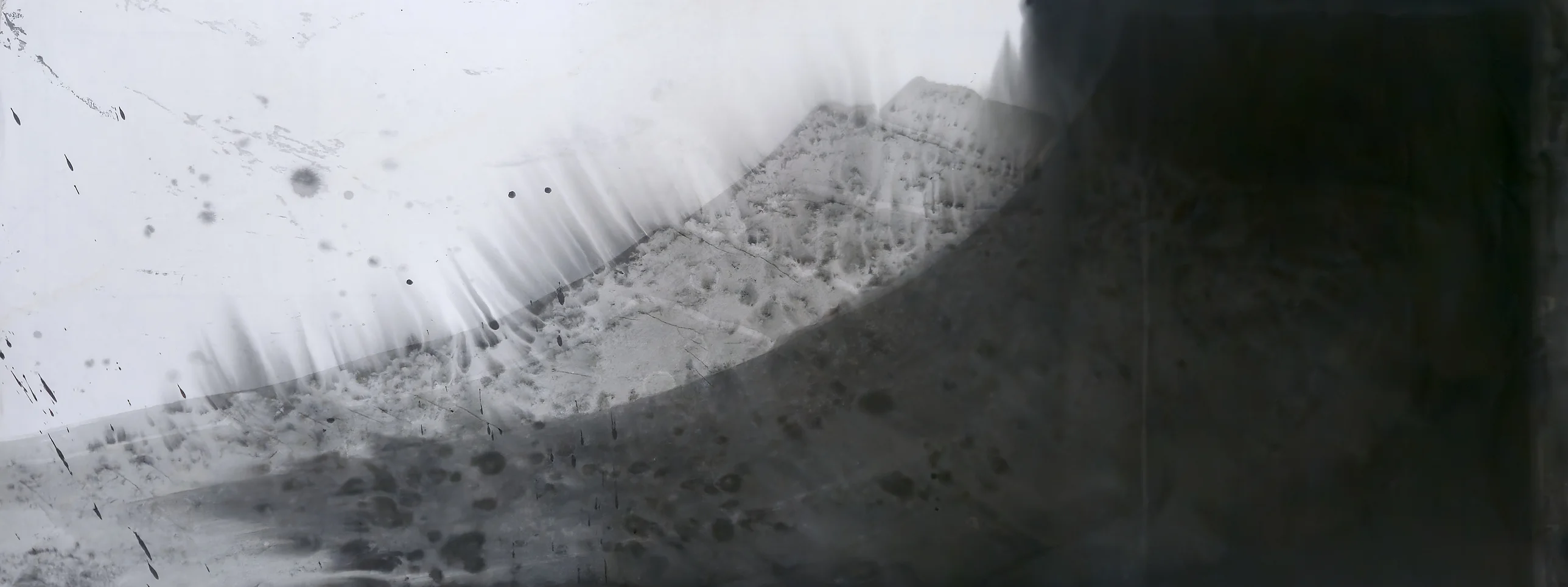 Grey arc rising from lower left to upper right with a feathered top edge, bare paper upper left, solid black block filling the right.