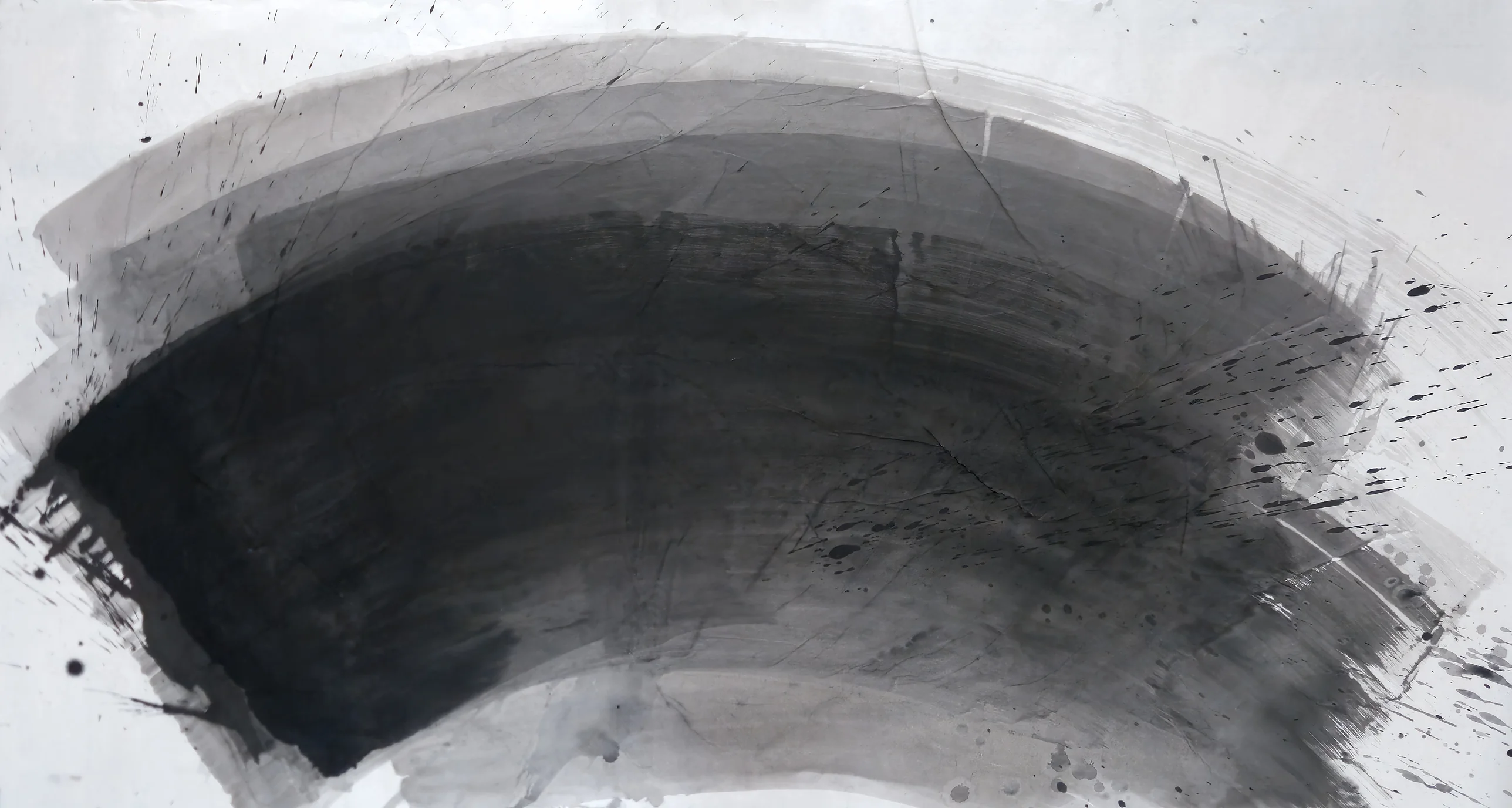 A wide dark arc sweeps from lower left over to lower right on white paper, with paler bands above and ink spatter at the right.