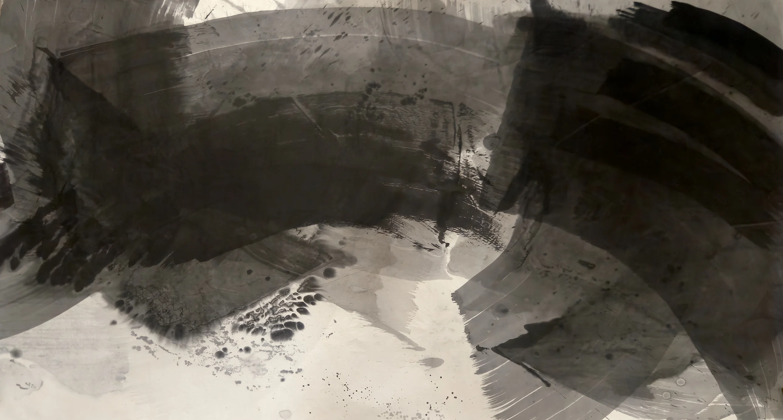 A dark ink arch spans a wide sheet: heavy black across the top, grey bands curving down the right, pale paper below centre.