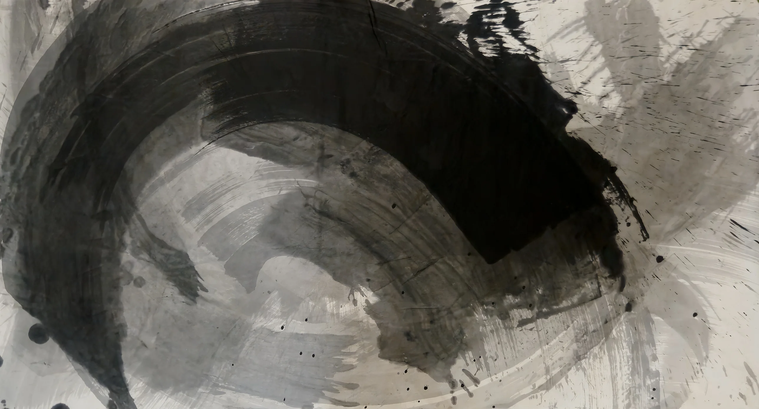 A broad black arc sweeps from lower left over the top to a square black end at right, around pale grey washes and spatter.