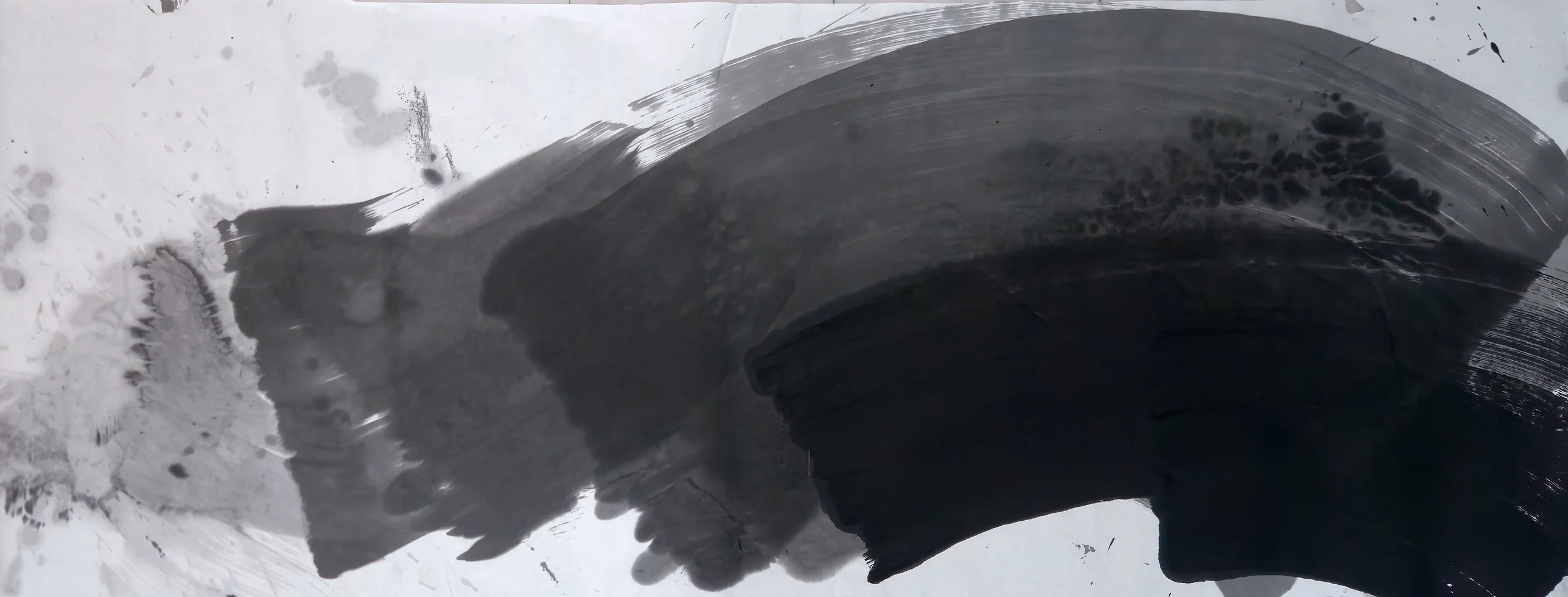 A wide ink arc sweeps from pale grey at left to dense black at lower right, rising toward the upper right, with stains at top left.