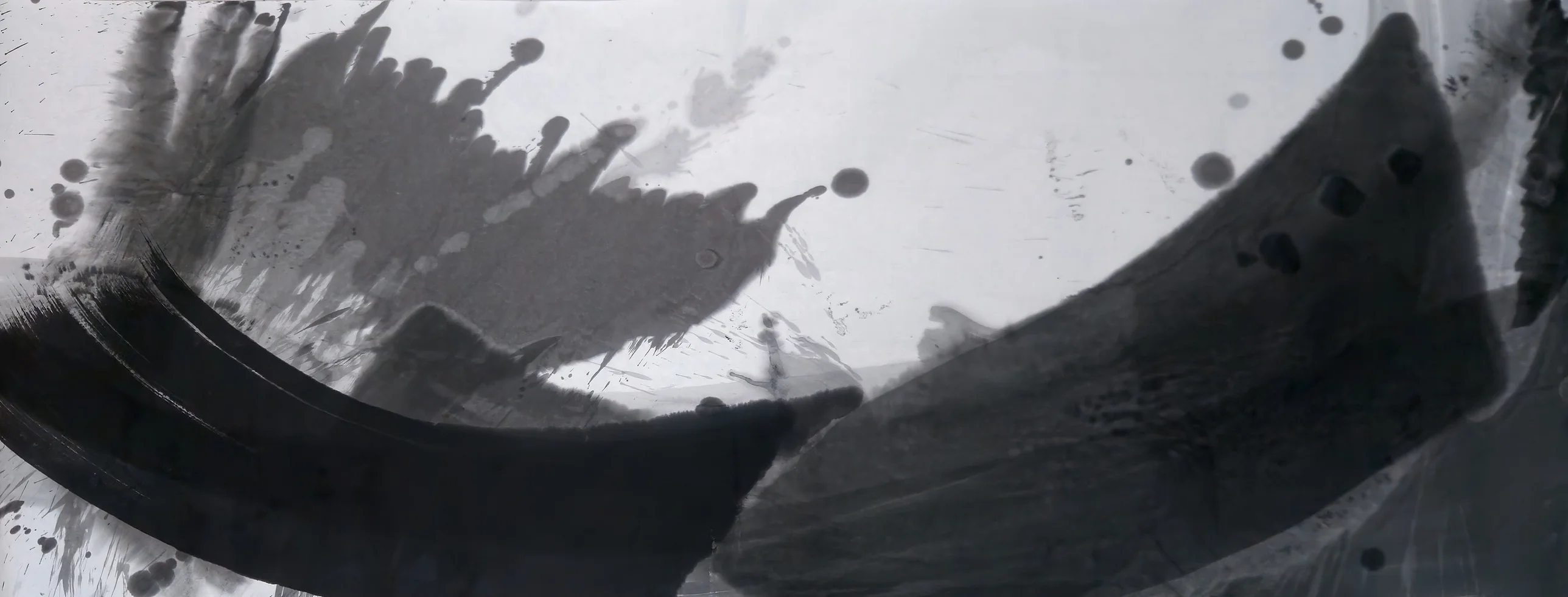 Wide ink painting: a black arc sweeps from the left edge to bottom centre, a grey wedge rises right, grey splashes upper left.