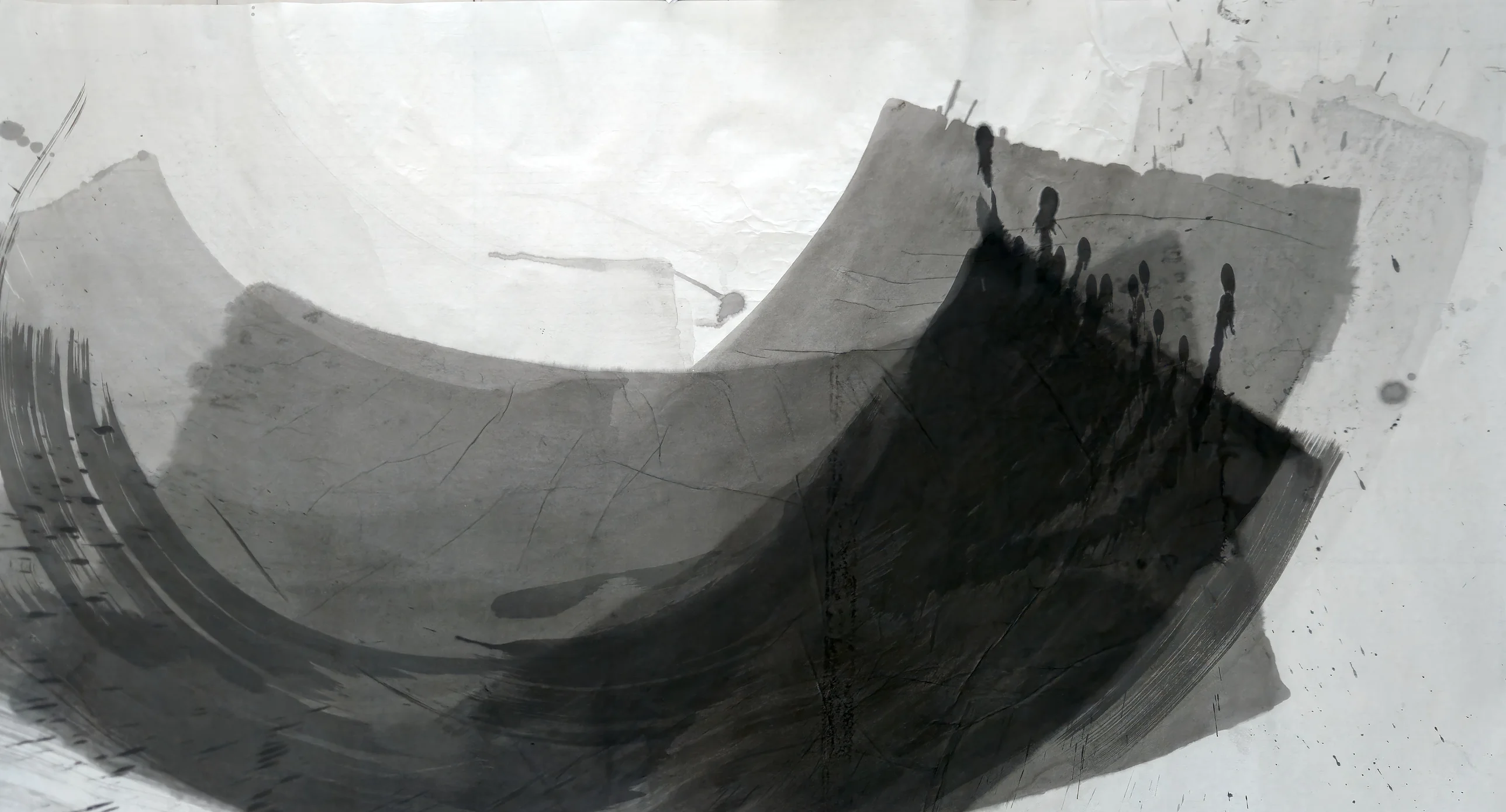 Large grey and black brush arcs form a bowl across a pale landscape sheet, rising at right into a dark wedge topped with drips.