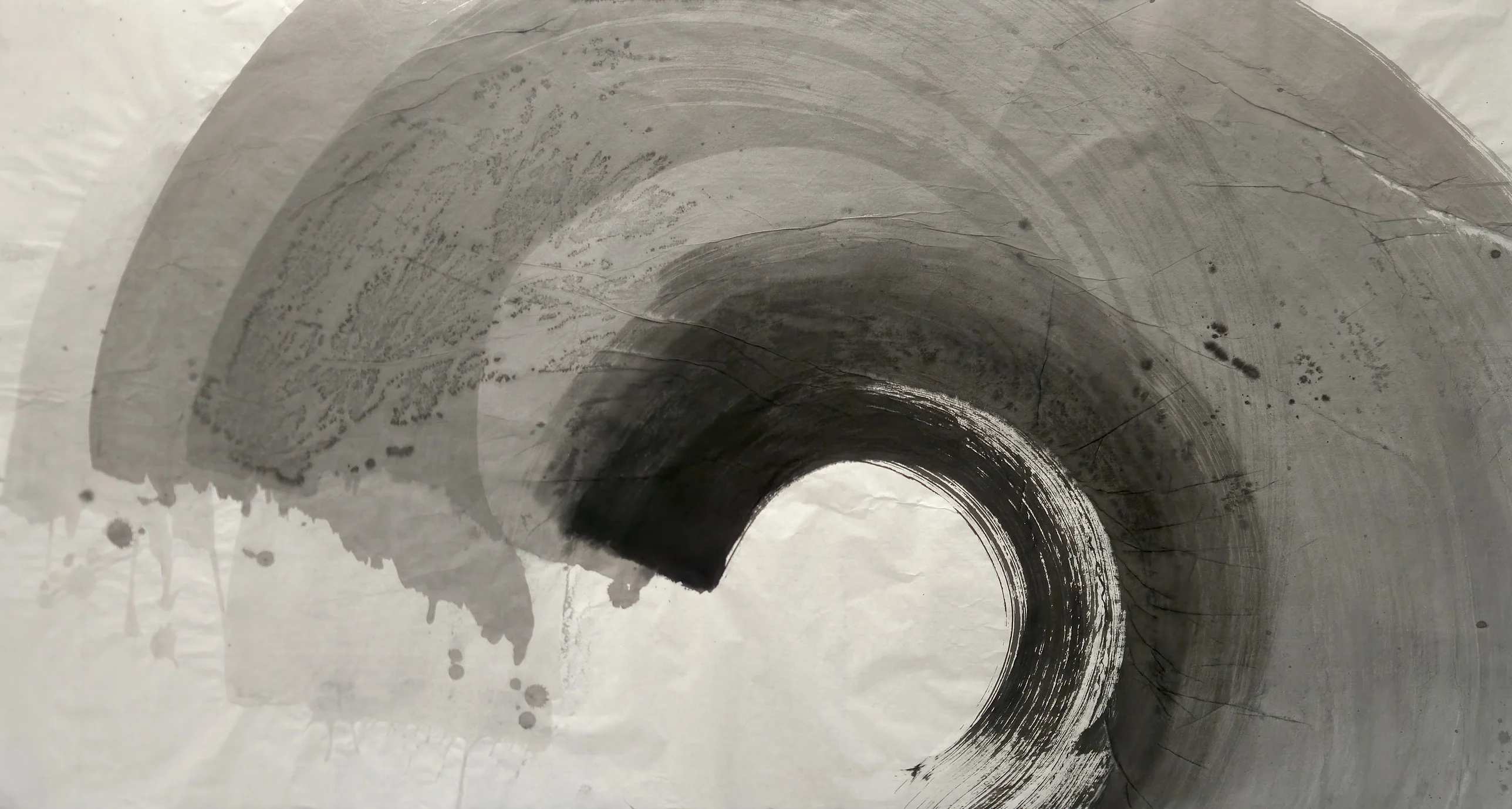 Grey concentric arcs sweep from upper left to the right, ending in a black dry-brush ring around a white disc, with drips at lower left.