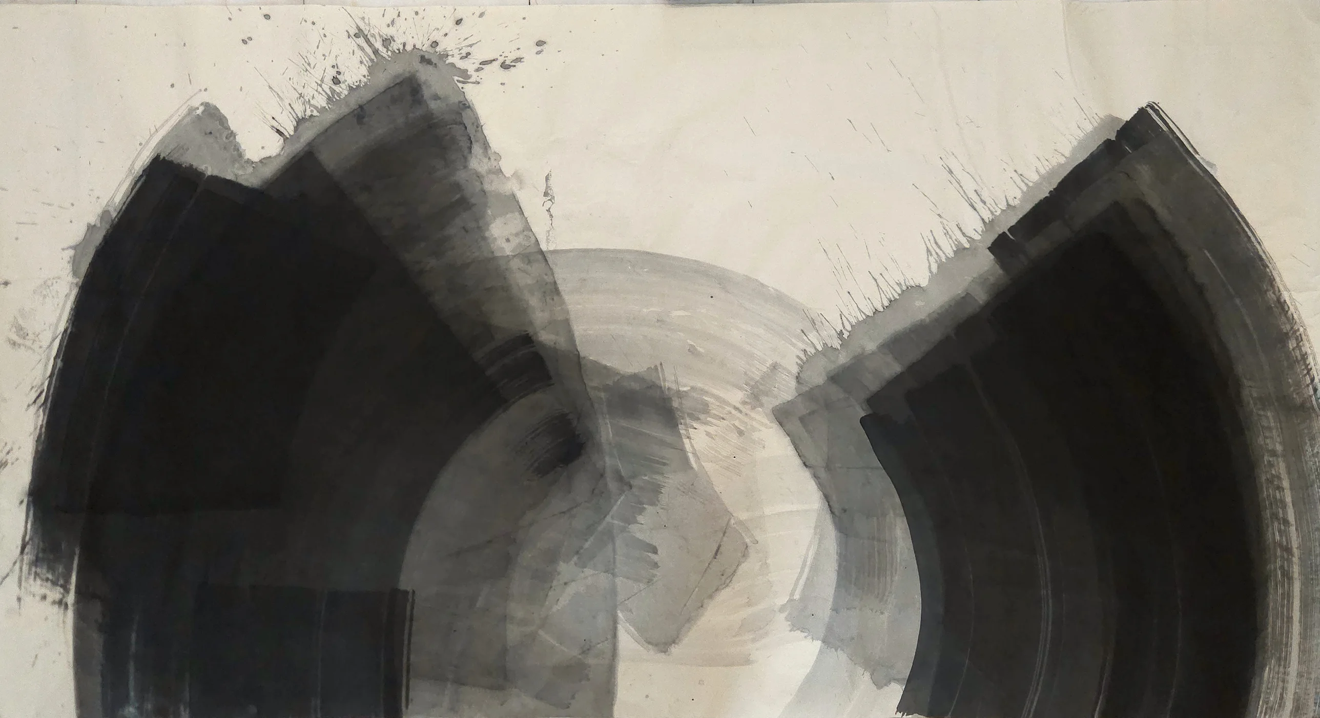 Two dark fan shapes rise from the bottom left and right, spattered at their tops, around a pale grey circle on cream paper.