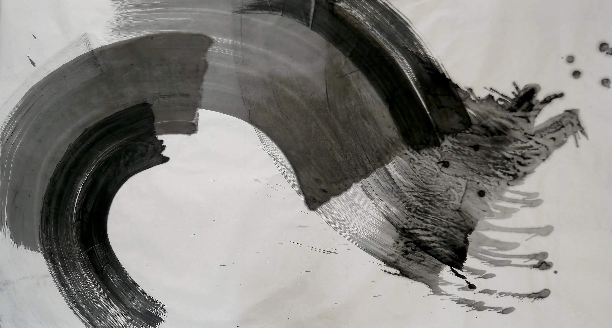 Grey and black brush arcs curl from lower left over the top around an empty pale centre, ending in a dark splash with drips at right.