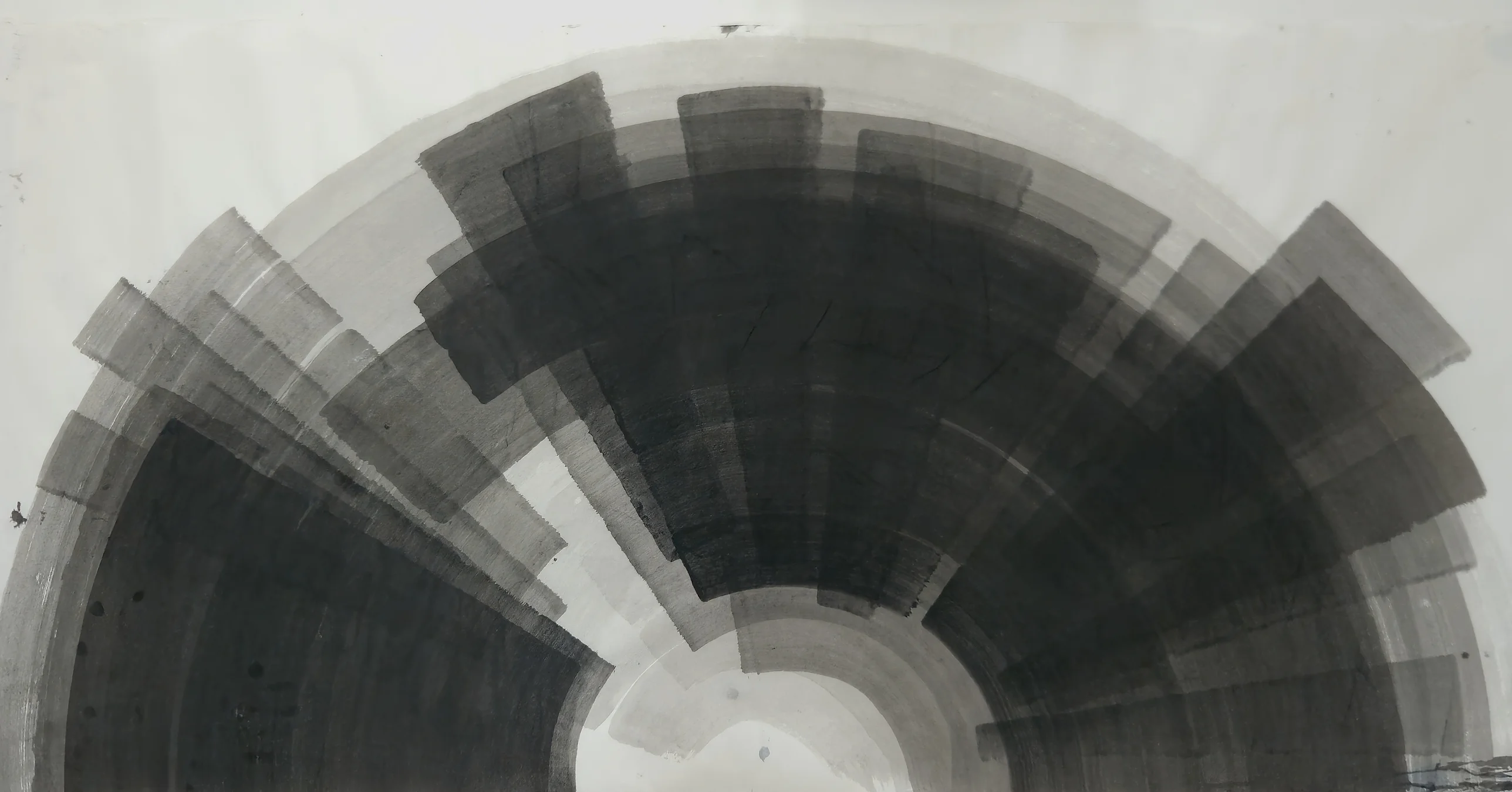 A large grey and black half wheel of broad curved strokes rises from the bottom edge around a pale centre on white paper.