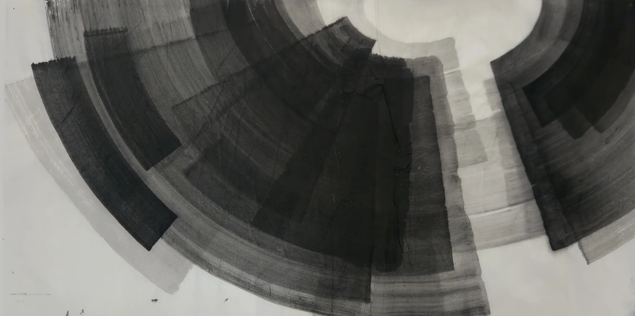 Large fan of curved grey and black bands sweeping from top left across the centre, a smaller dark arc at right, white paper between.