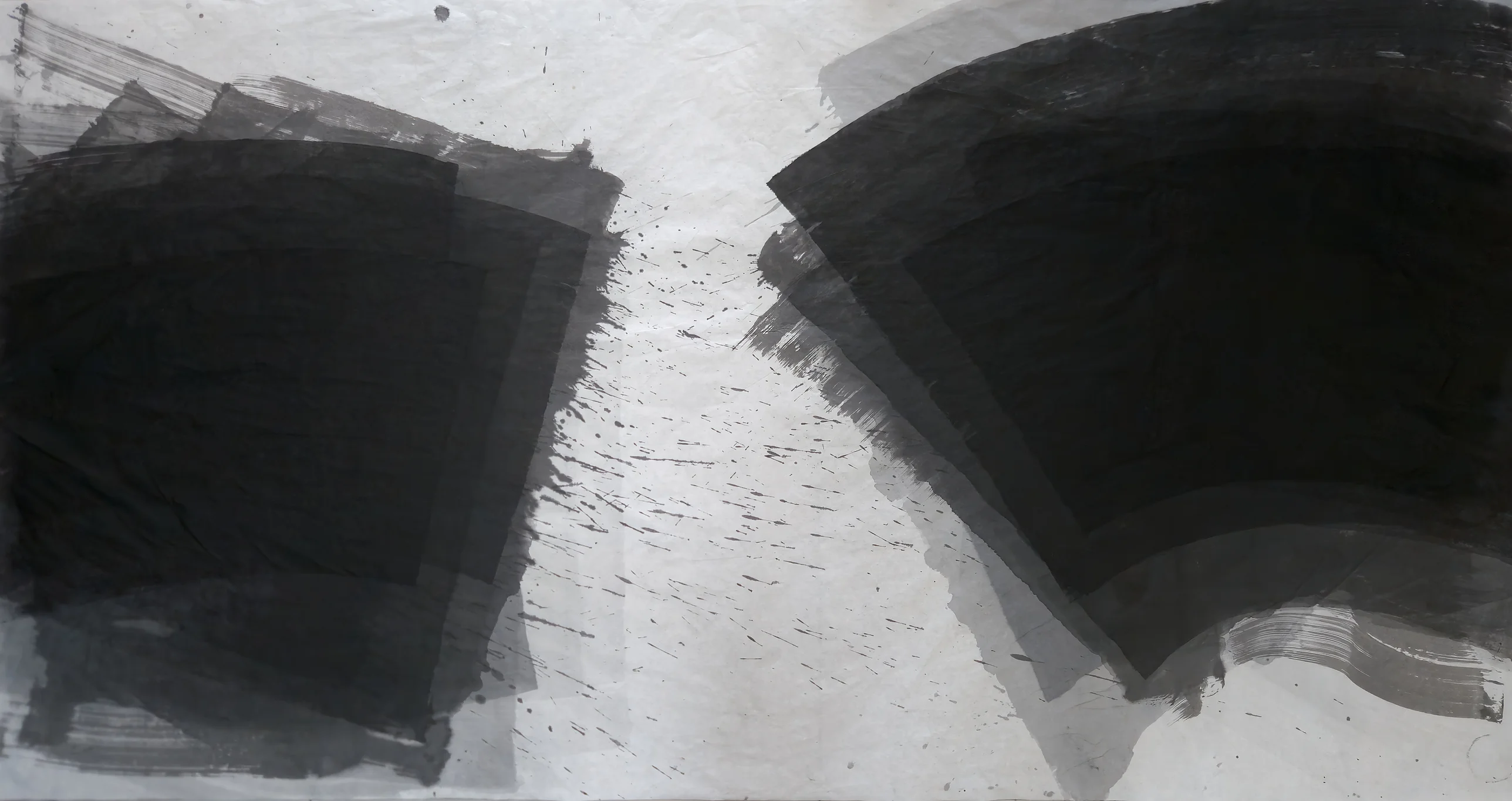 Two black ink masses, a square block at left and a curved fan at upper right, face each other across pale paper streaked with spatter.