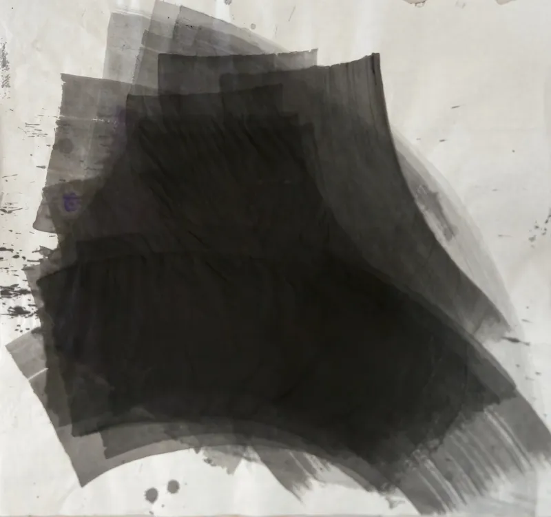 T_374: A large black mass of stacked curved grey bands sweeps toward the lower right on pale paper, with spatter at left and drops below.